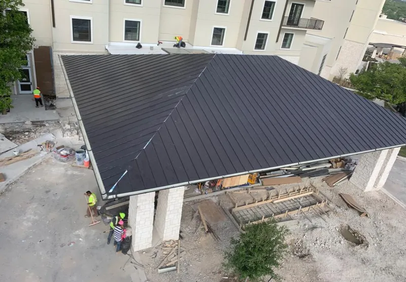 Metal roofing installation team working on a commercial building in Spring